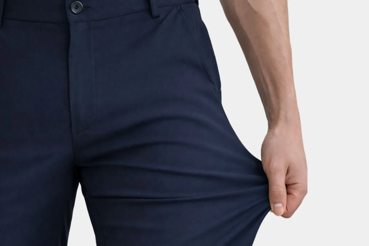Hand stretching the fabric of a pair of trousers